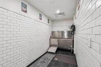 A white tiled bathroom with a sink and a toilet. at LiveWell Apartments, Pittsburgh 15222